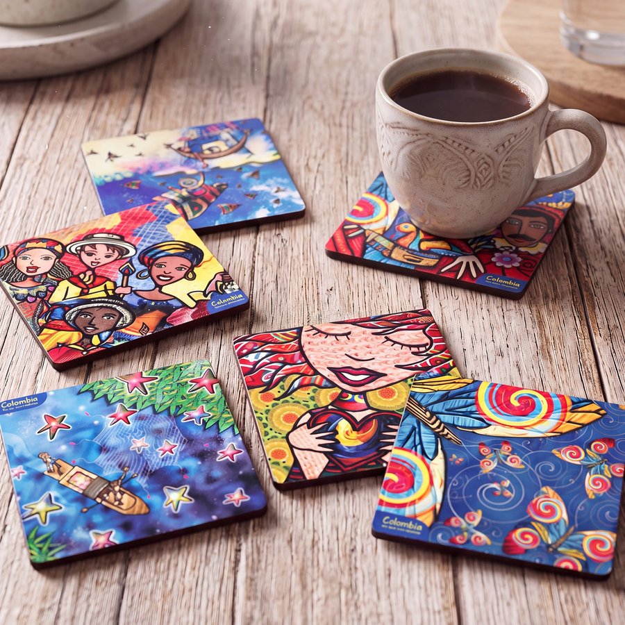Seis portavasos ilustrados repartidos sobre una mesa de madera, junto a un pocillo de café