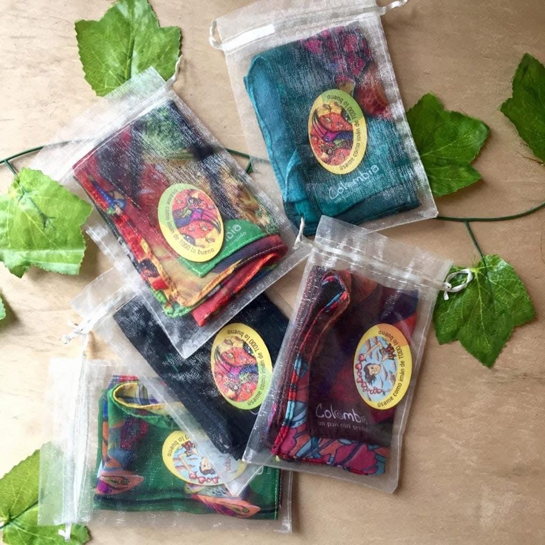 Pañoletas dobladas dentro de sus bolsas de organza, cada una con su sello ilustrado